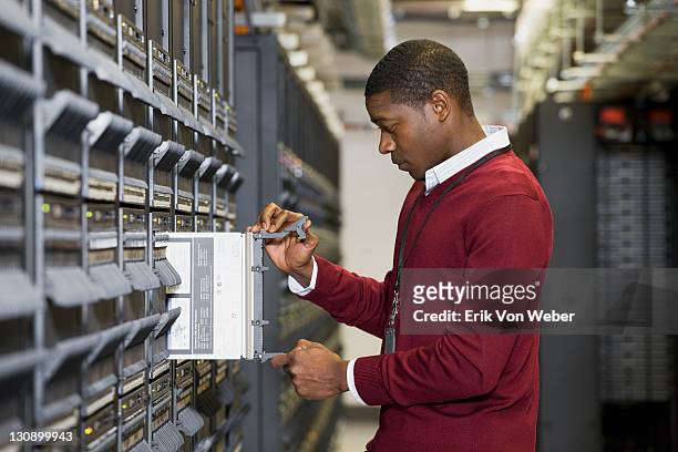 african american man in a server room. - computer server stock pictures, royalty-free photos & images