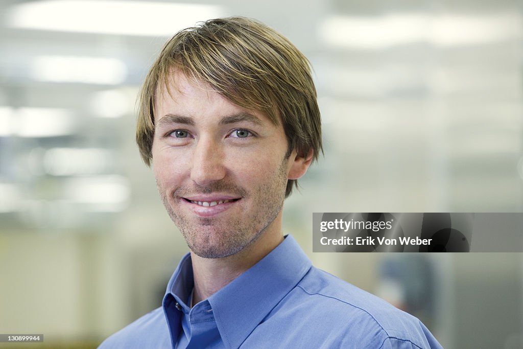 Portrait of a young man in an office space.