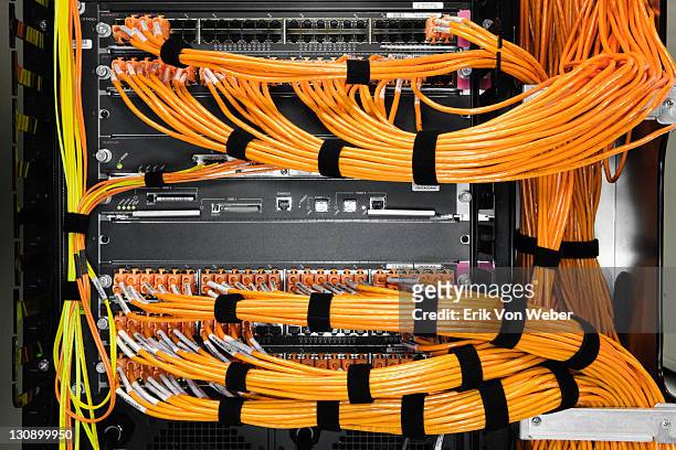 detail of orange cables in a server room. - cable stockfoto's en -beelden