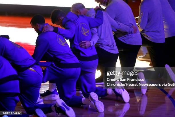 Golden State Warriors' Stephen Curry joins teammates and coaching staff in kneeling during National Anthem before playing Los Angeles Clippers during...