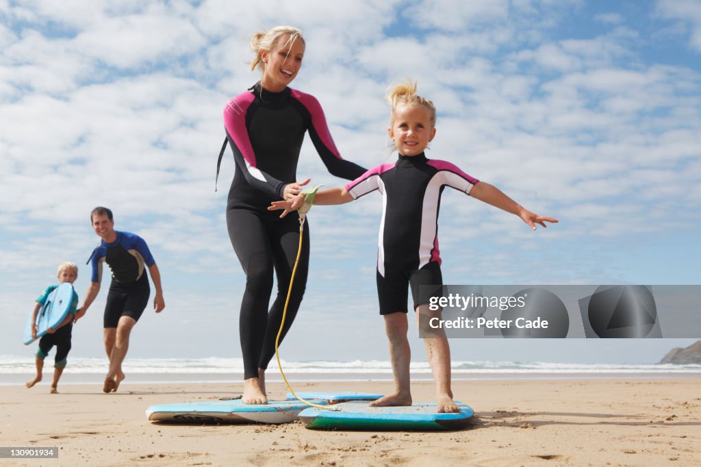 Family plaing on beach with bodyboards