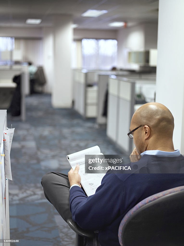 Reviewing Notes While Commuting A Man Reviewing His Notes In An Office High-Res Stock Photo - Getty Images