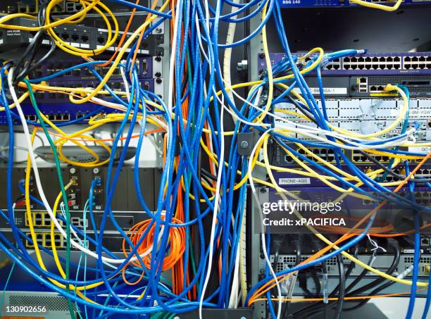 a tangled mess of network cables - computer cable stock pictures, royalty-free photos & images