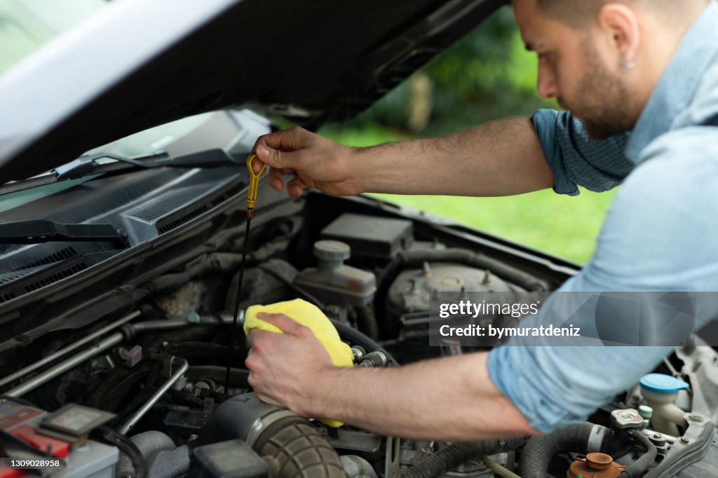 Mechanic measuring the oil level of an engine at an auto shop