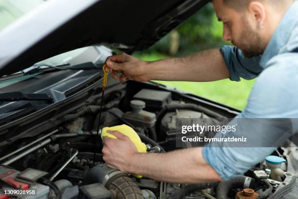 mechanic measuring the oil level of an engine at an auto shop - rag stock pictures, royalty-free photos & images