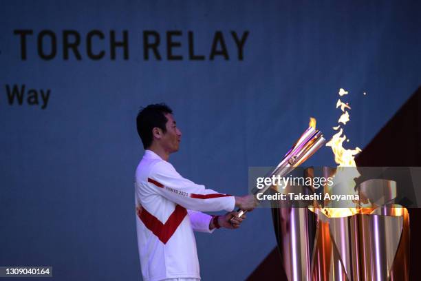 Last torch bearer of Day 1, aerobatics pilot Yoshihide Muroya lights the cauldron at Hibarigahara field during the Tokyo Olympic Games torch relay on...