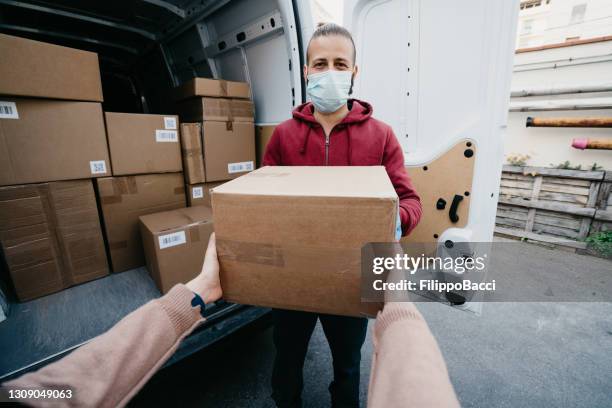 vista de pov de una mujer recibiendo un paquete de un repartidor - receiving fotografías e imágenes de stock