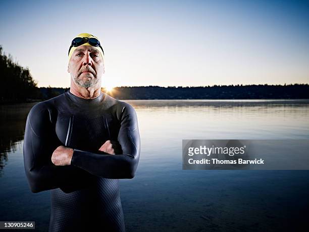 male triathlete standing in water arms crossed - beginner triathlon stock pictures, royalty-free photos & images