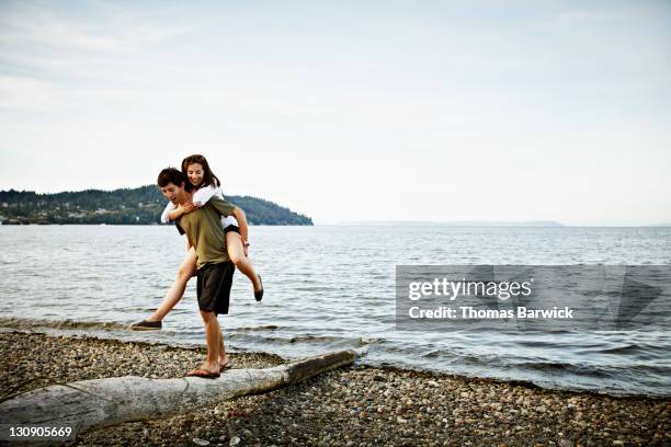 boyfriend carrying girlfriend on back - seattle people stock pictures, royalty-free photos & images