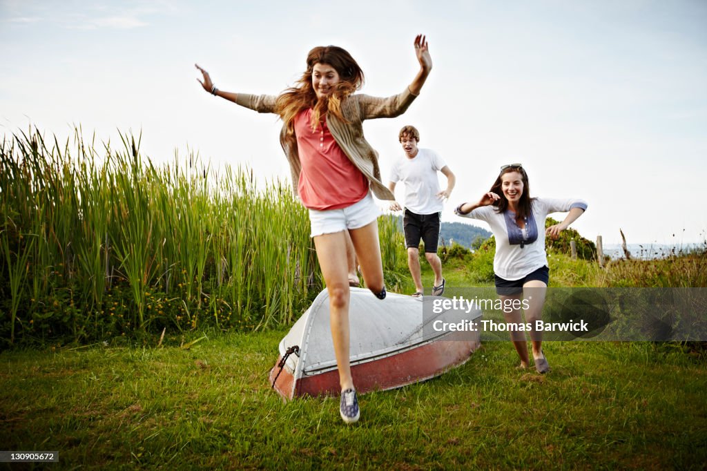 Group of friends running and jumping over boat