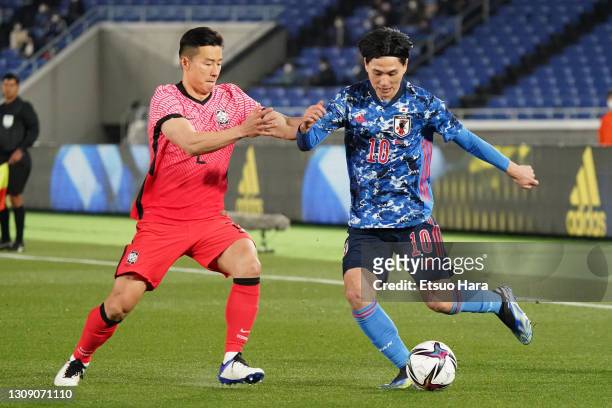 Takumi Minamino of Japan and Kim Taehwan of South Korea compete for the ball during the international friendly match between Japan and South Korea at...