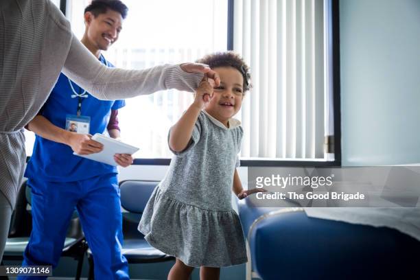 mother and daughter in medical exam room - nurse child stock-fotos und bilder