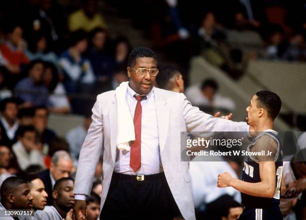 Georgetown coach John Thompson confers on the sideline with point guard Charles Smith, during a game against the University of Connecticut, Hartford,...