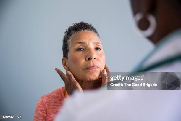 doctor examining throat of patient in clinic - film festival screening of behind the curve stockfoto's en -beelden