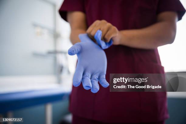 midsection of female nurse wearing protective gloves in hospital - glove ストックフォトと画像