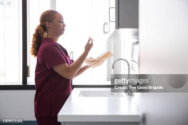 female nurse cleaning hands in hospital - nurse maroon stock pictures, royalty-free photos & images
