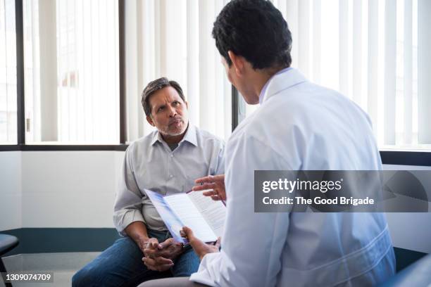rear view of male doctor talking with senior patient - man talking to doctor bildbanksfoton och bilder