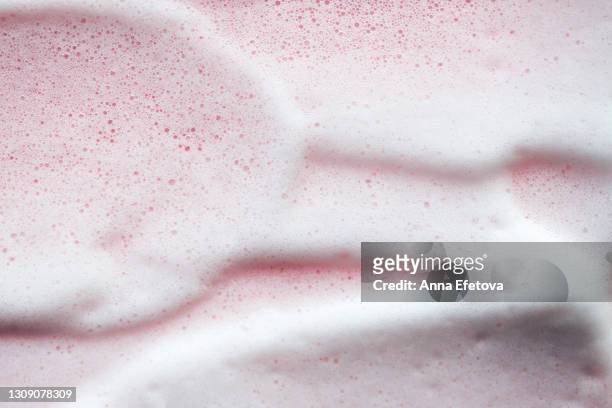 texture of white foam on rose background. selfcare is a trendy procedure of the year. cosmetics banner with copy space - aufschäumen stock-fotos und bilder