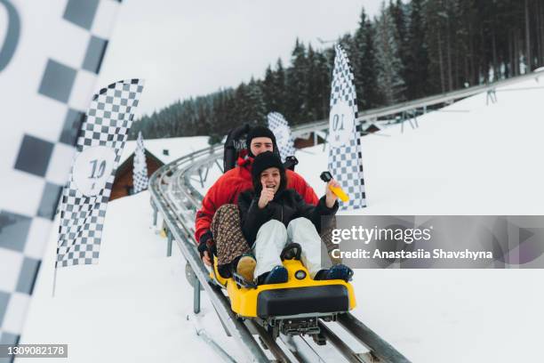 junges paar auf der achterbahn im winter in den bergen - young woman screaming on a rollercoaster stock-fotos und bilder