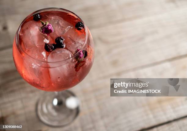 pink gin tonic glass in top view with wooden base - gin and tonic stock pictures, royalty-free photos & images