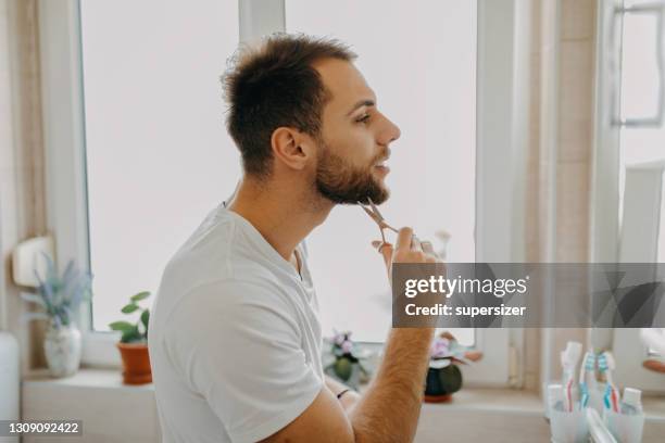 beautiful young man getting ready in the morning - beard trimming stock pictures, royalty-free photos & images