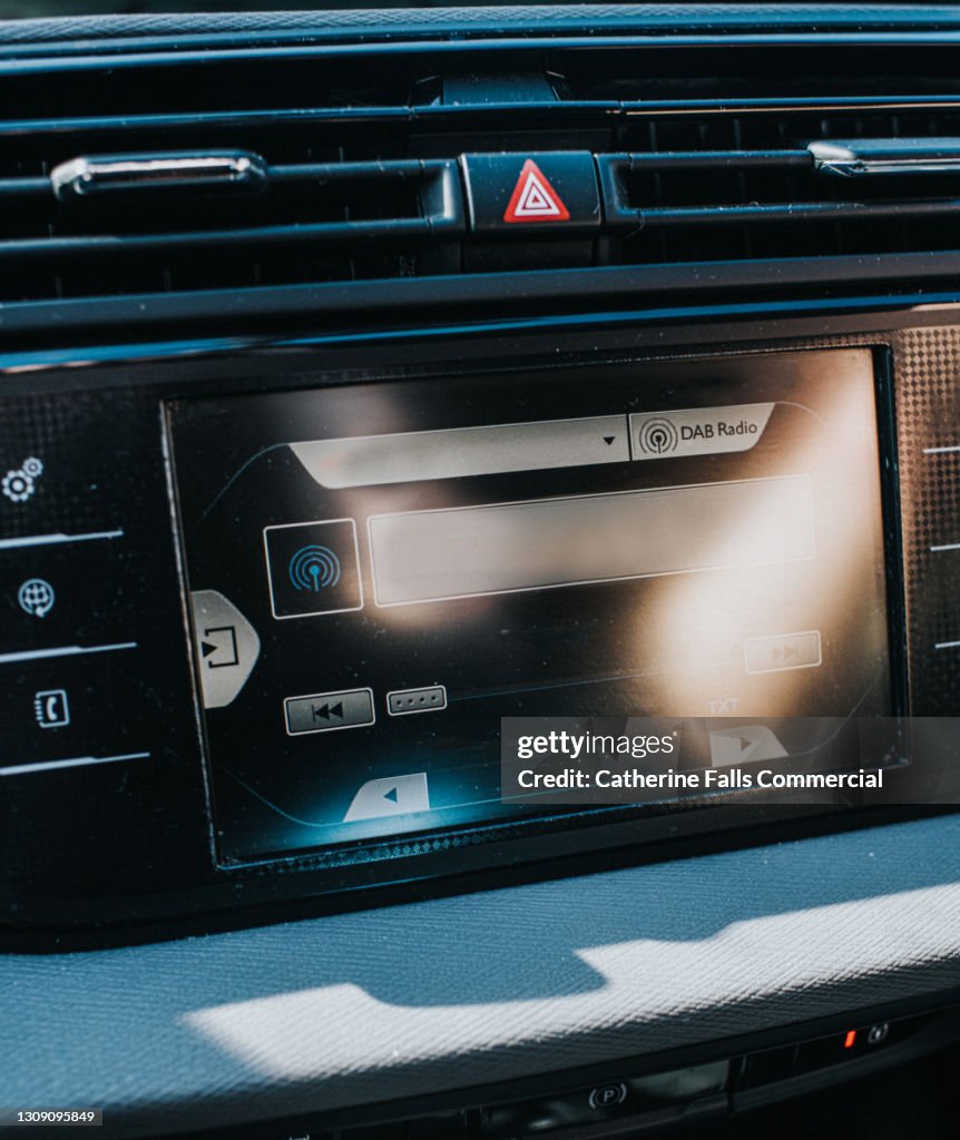 A digital display screen on the dashboard of a modern car, from an vehicle interior point of view