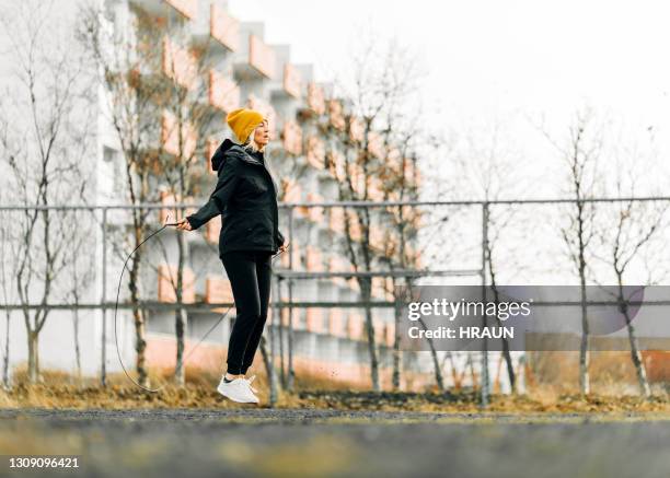 mujer madura saltando cuerdas al aire libre por la mañana - dar brincos fotografías e imágenes de stock