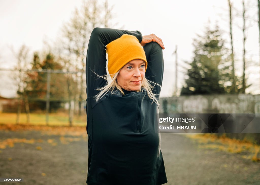 Jogger doing arm stretches in morning