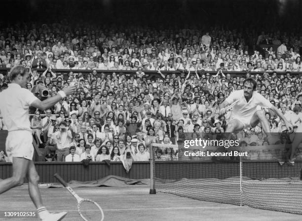 John Newcombe of Australia jumps over the net after defeating Stan Smith of the United States in their Men's Singles Final match on Centre Court at...