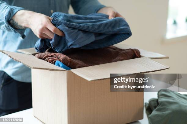 vrijwilliger met schenkingsdoos met kleren - packing parcel stockfoto's en -beelden