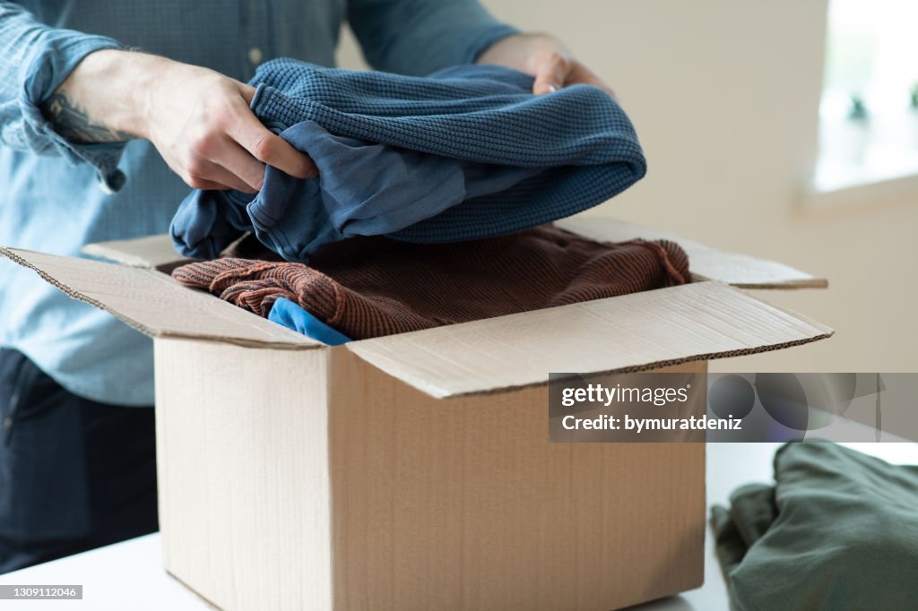 Voluntário com caixa de doação com roupas