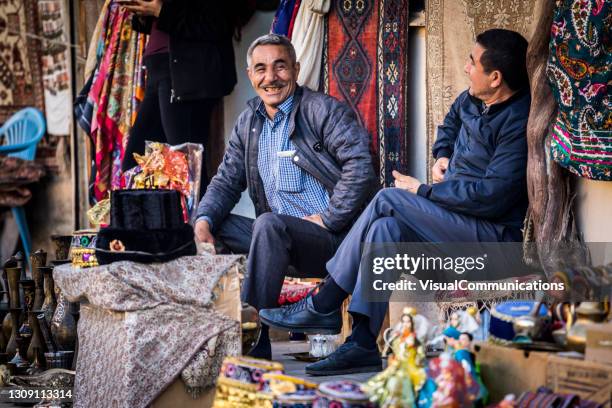 local men sitting in front of their shops in baku. - azerbaijan people stock pictures, royalty-free photos & images
