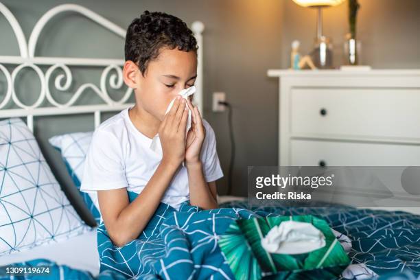 young boy in bed, feeling sick - respiratory disease stock pictures, royalty-free photos & images