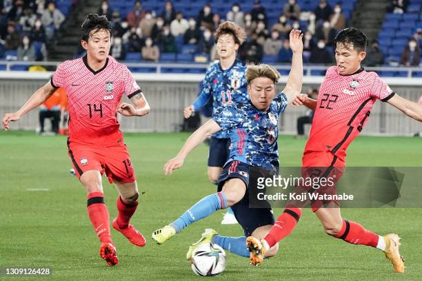 Takuma Asano of Japan and Jeong Wooyeong of South Korea compete for the ball during the international friendly match between Japan and South Korea at...