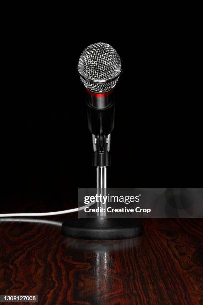 a microphone in a stand, on a wooden desktop - microzoa stock pictures, royalty-free photos & images