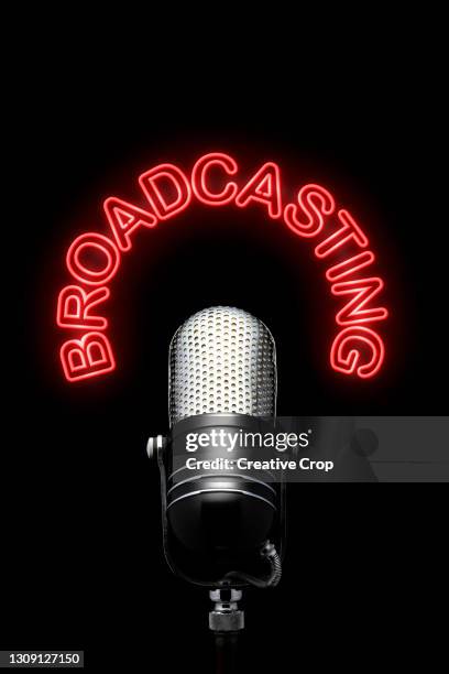 a chrome microphone underneath a red neon broadcasting sign - microzoa stock pictures, royalty-free photos & images