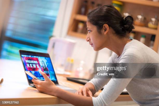 indian young adult woman looking at laptop - watching news stock pictures, royalty-free photos & images