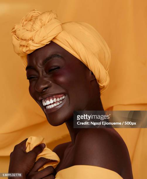 portrait of smiling young black woman wearing yellow headscarf,lagos,lagos,nigeria - blusher fotografías e imágenes de stock
