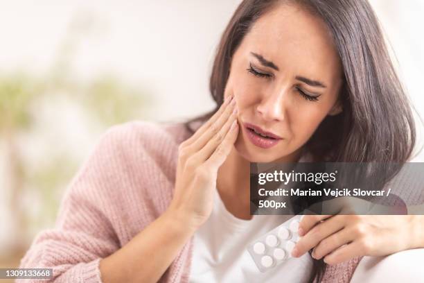 beautiful woman suffering from toothache - pijnstiller stockfoto's en -beelden