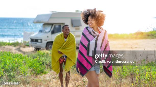 afro couple in love enjoying their romantic summer vacation with camper . - rv beach stock pictures, royalty-free photos & images