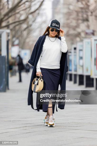 Model and DJane Gitta Saxx wearing a white sweater pullover by Sonja Kiefer Studio, a dark blue wrap skirt by Sonja Kiefer Studio, sunglasses by...