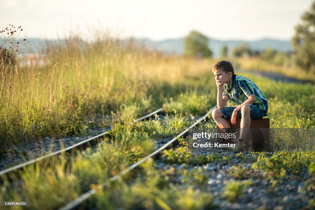 Junge mit Sack balancieren auf Gleisen