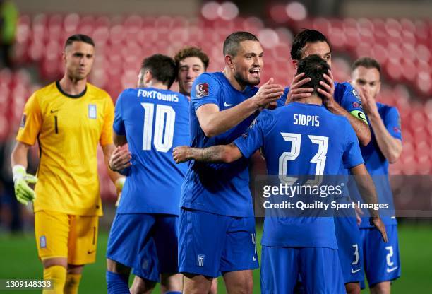 Manolis Siopis of Greece celebrates with team mates Giorgos Tzavellas and Kyriakos Papadopoulos following the FIFA World Cup 2022 Qatar qualifying...