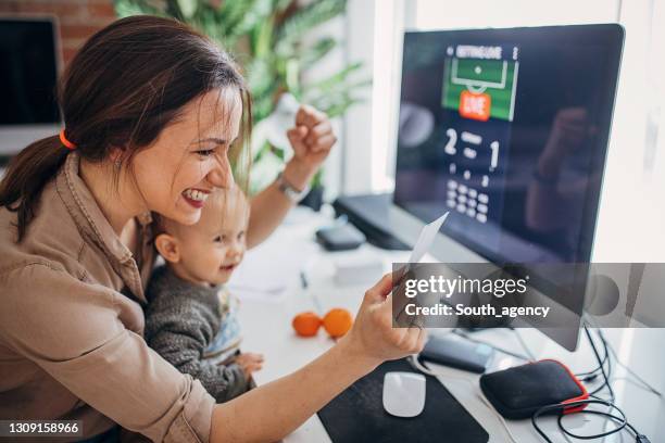 modern mom and baby son betting online - winning ticket stock pictures, royalty-free photos & images