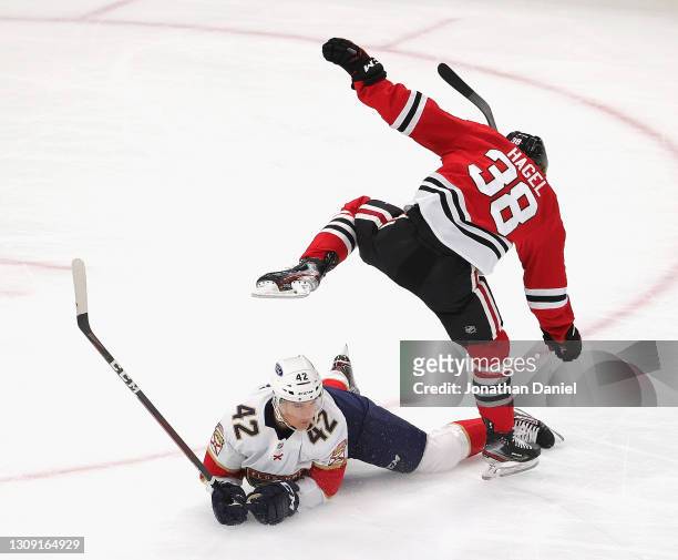 Brandon Hagel of the Chicago Blackhawks jumps over Gustav Forsling of the Florida Panthers in the first period at the United Center on March 25, 2021...