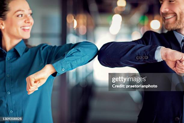 business people doing elbow bump greeting during covid-19 pandemic - elbow bump stock pictures, royalty-free photos & images