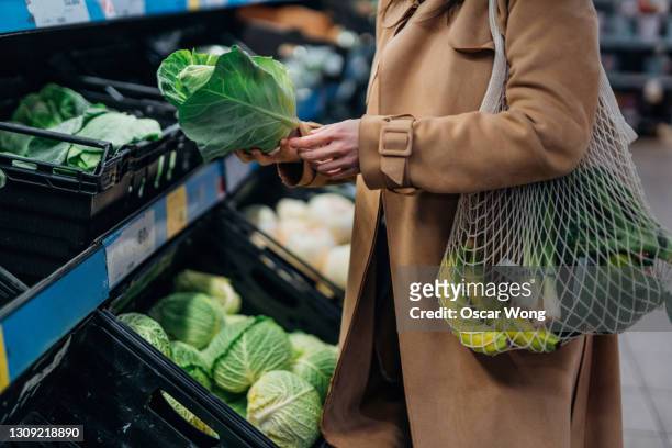 woman shopping for fresh organic fruits and vegetables in supermarket - crucifers stock pictures, royalty-free photos & images