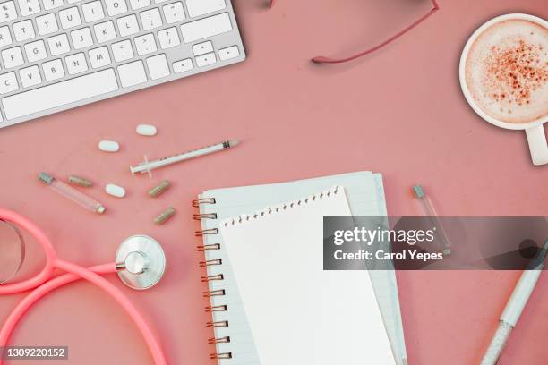 doctor desk with coffee, open notebook, pills, stethoscope - coffee top view stock-fotos und bilder