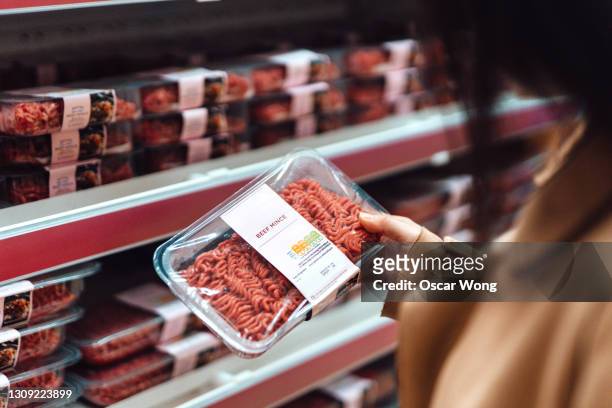 woman shopping for fresh organic fruits and vegetables in supermarket - meat stockfoto's en -beelden