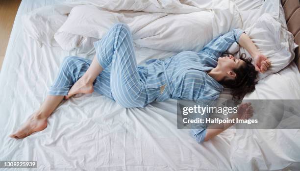 top view of woman in pajamas sleeping in bed in bedroom. - pajamas fotografías e imágenes de stock